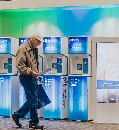 old man walking past flowater refill stations