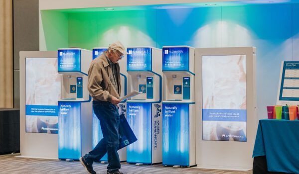 old man walking past flowater refill stations